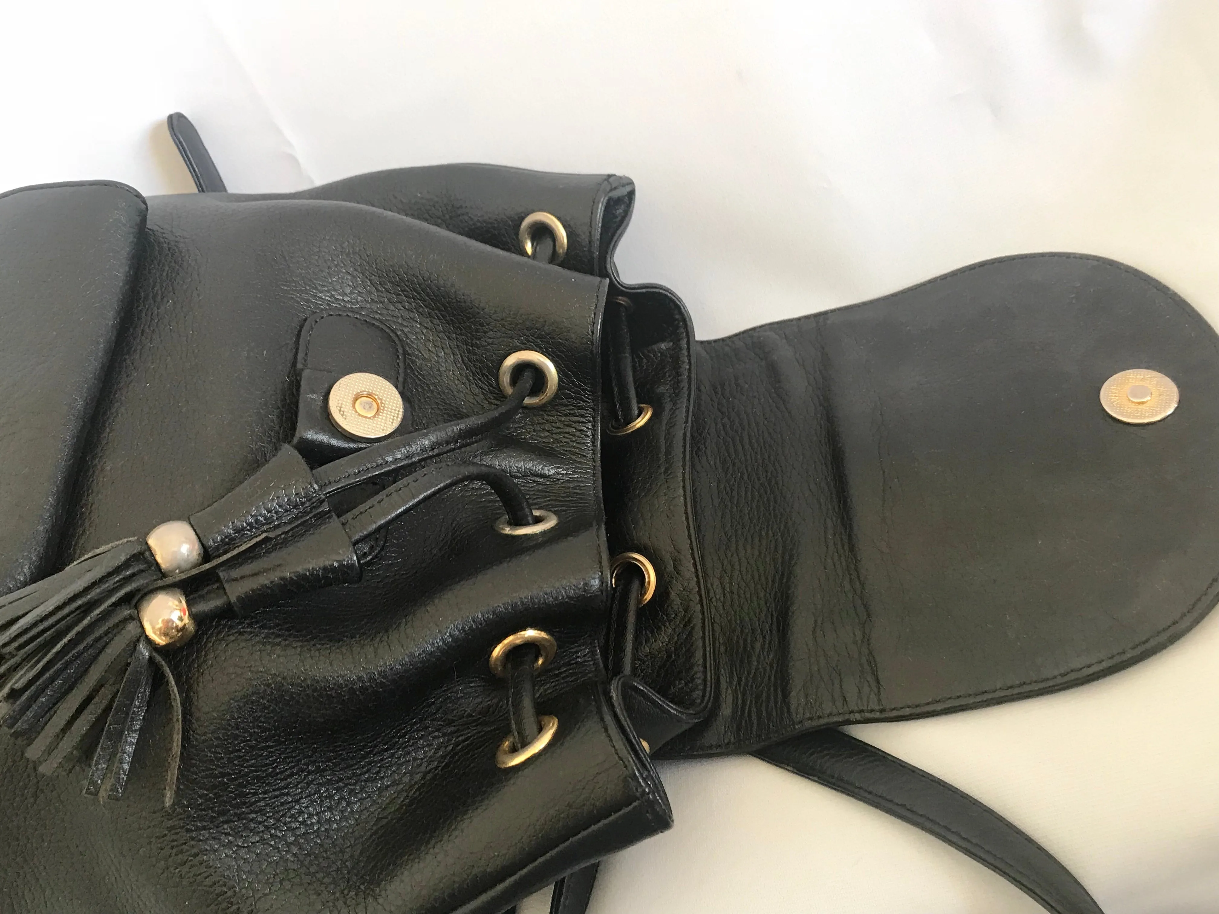 Vintage MCM black backpack with golden studded logo motifs and drawstrings. Designed by Michael Cromer. Unisex bag for daily use.
