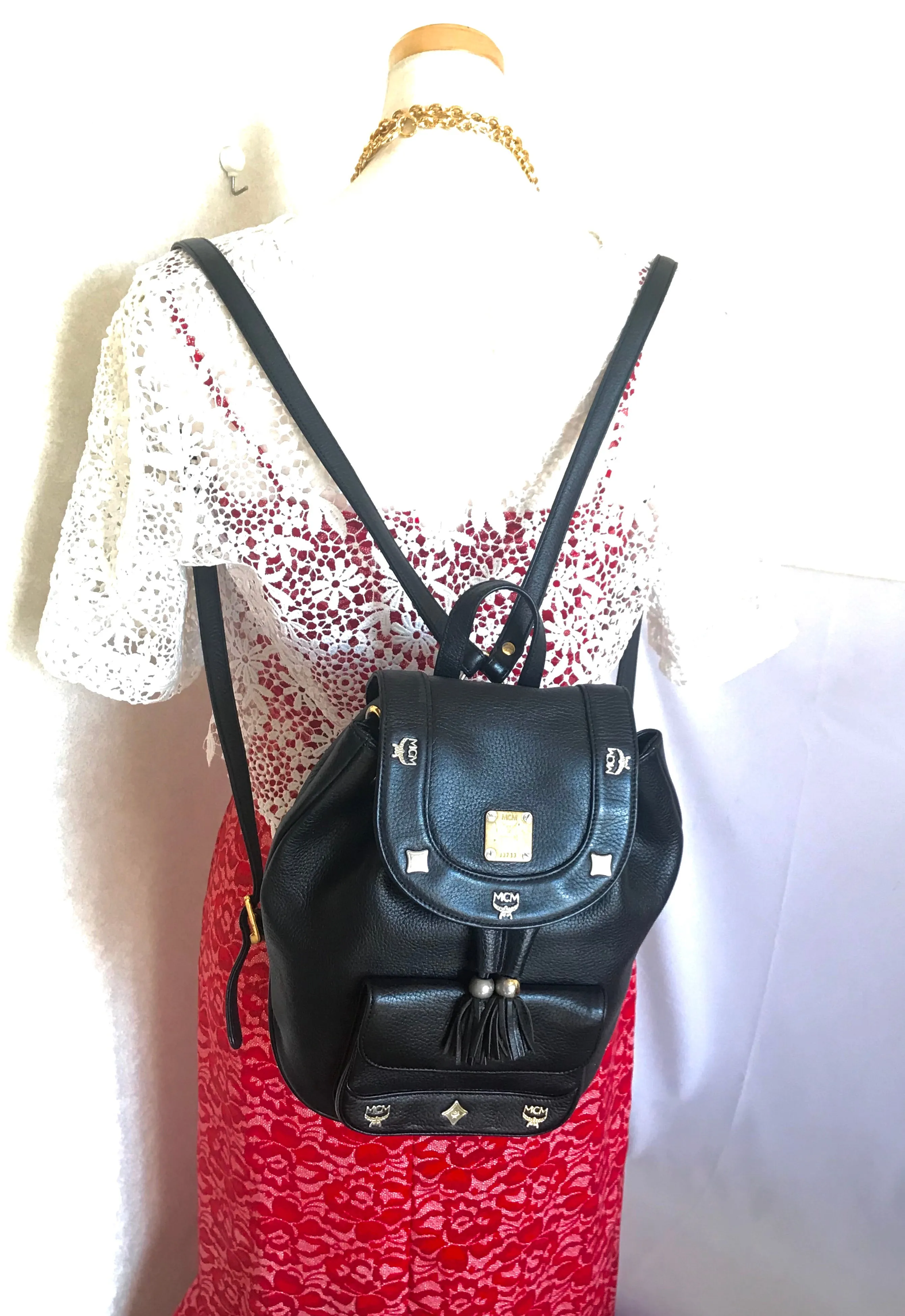 Vintage MCM black backpack with golden studded logo motifs and drawstrings. Designed by Michael Cromer. Unisex bag for daily use.