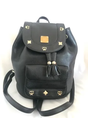 Vintage MCM black backpack with golden studded logo motifs and drawstrings. Designed by Michael Cromer. Unisex bag for daily use.