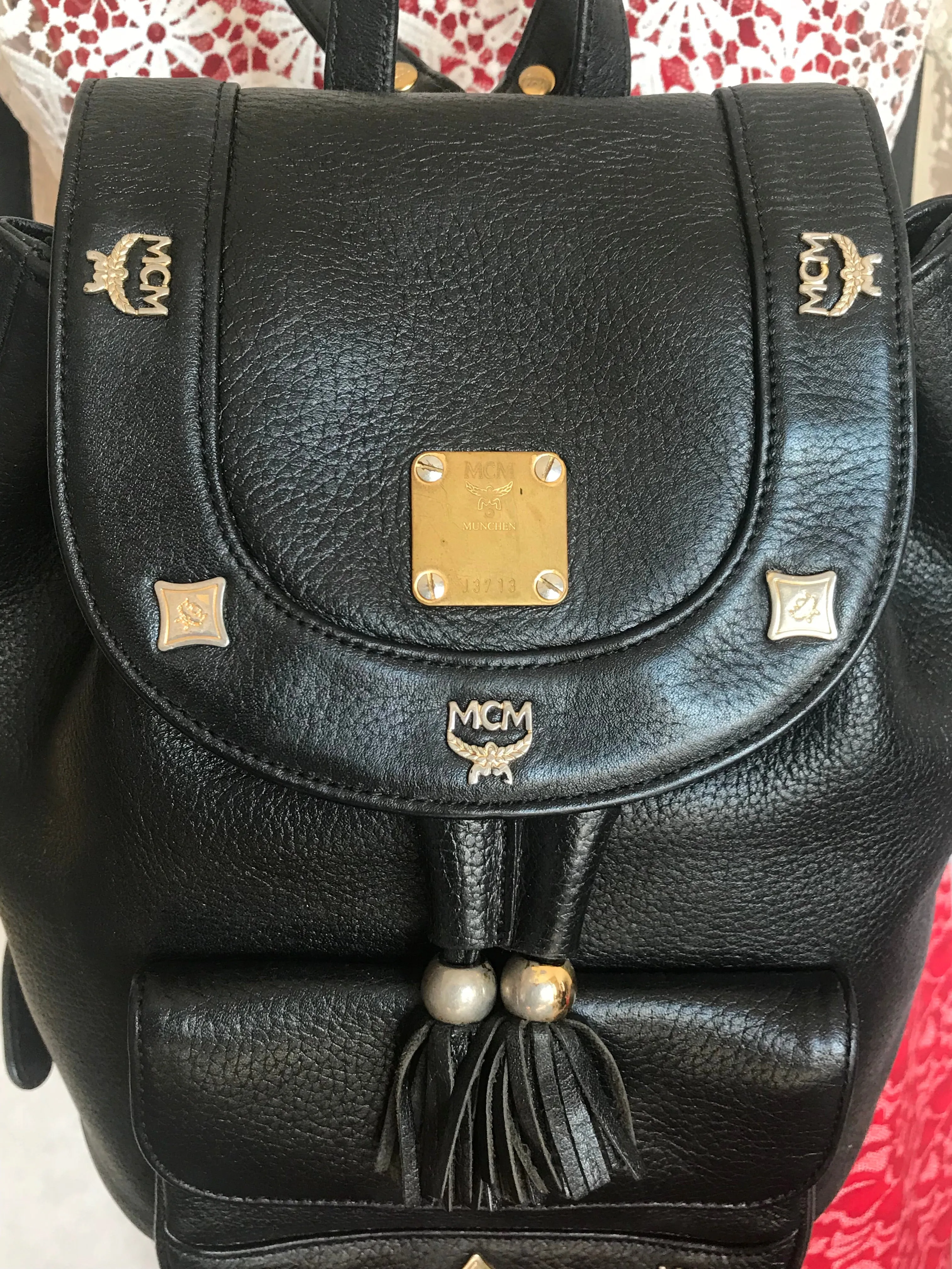 Vintage MCM black backpack with golden studded logo motifs and drawstrings. Designed by Michael Cromer. Unisex bag for daily use.